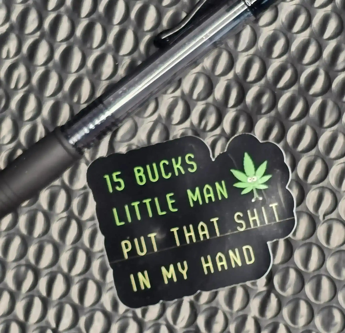 Cady Creations sticker with green text, cartoon leaf, and a pen on a textured surface