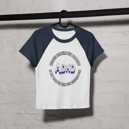 White and navy women’s raglan baby tee with ADHD graphic text, hanging on black hanger