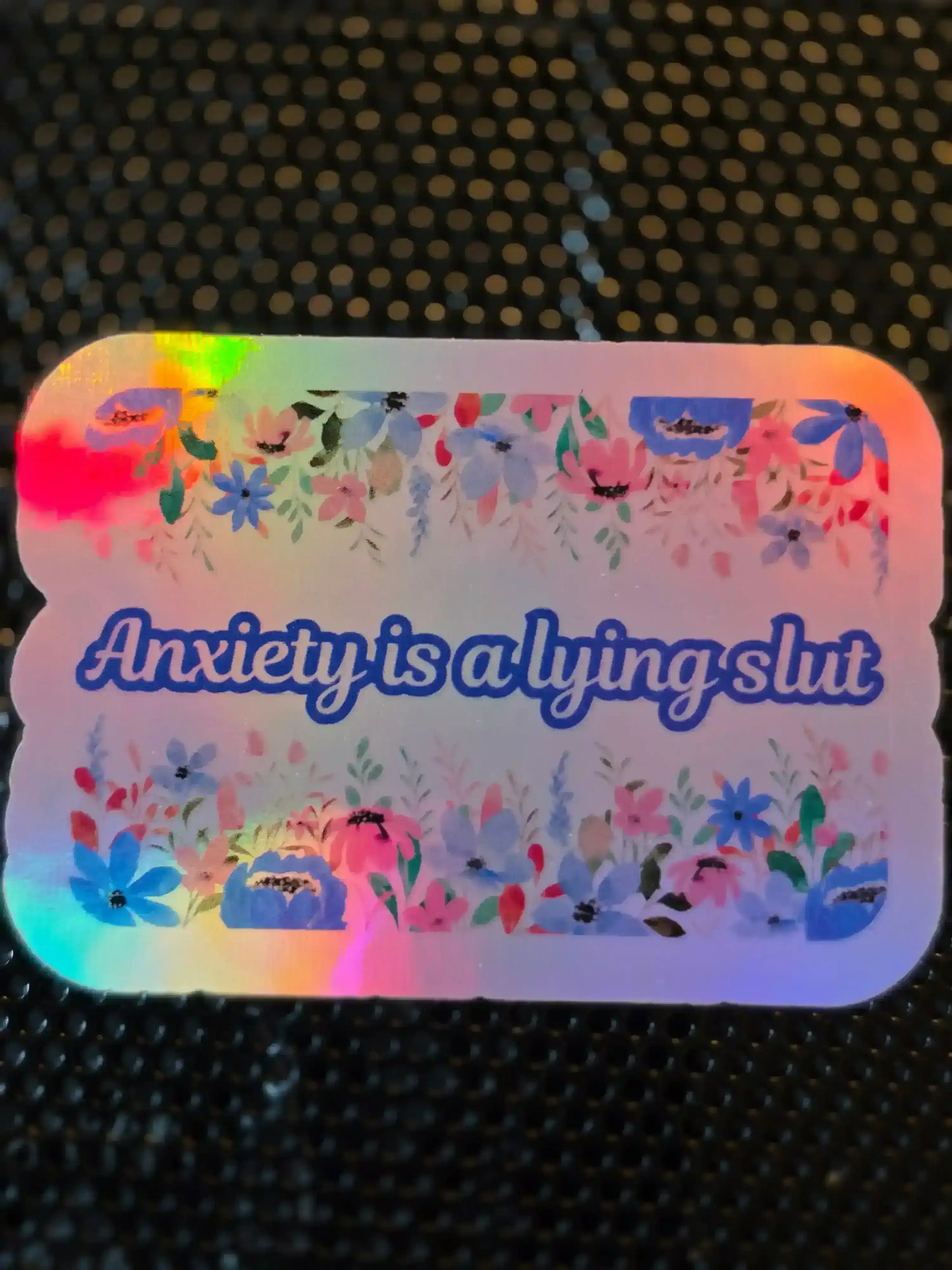 Holographic Cady Creations sticker with 'Anxiety is a lying slut' and floral border