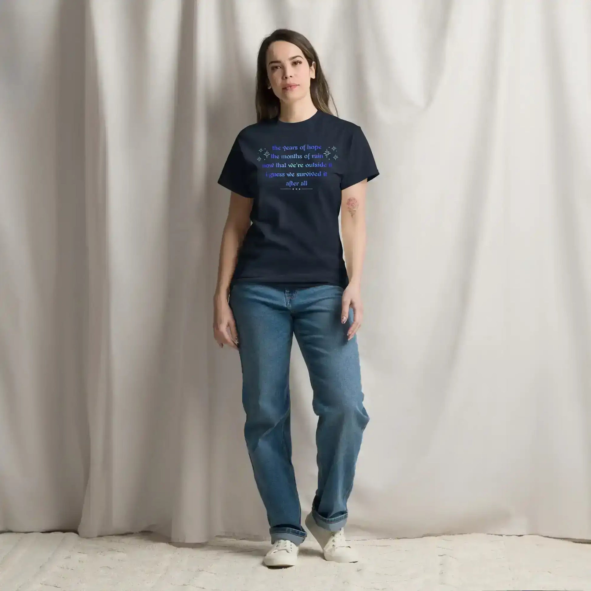 Woman wearing navy Cady Creations graphic tee with blue text, casual jeans, standing indoors