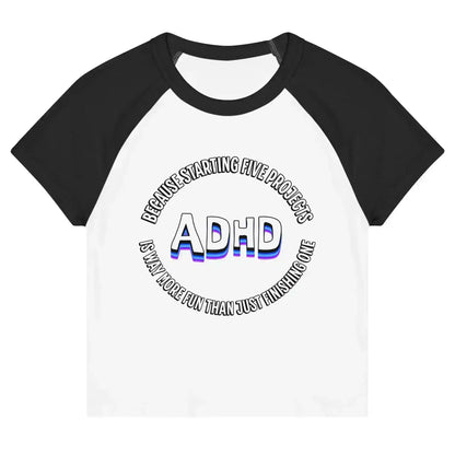 Women’s white and black raglan baby tee with ADHD graphic text from Cady Creations