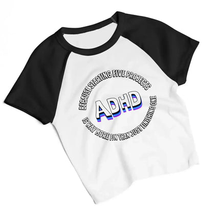 White and black women's raglan baby tee with 'ADHD' and humorous text, Cady Creations graphic tee