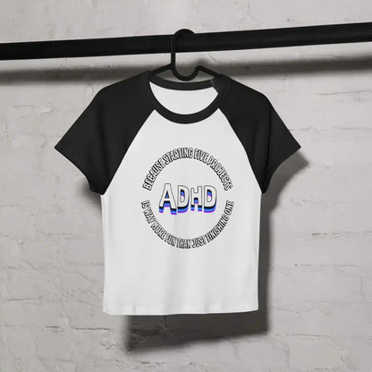 White and black women's raglan baby tee with ADHD graphic text, hanging on a black rod