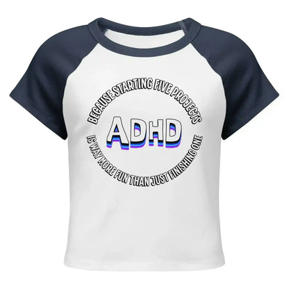 Cady Creations women's white and navy baby tee with ADHD graphic text design on front.