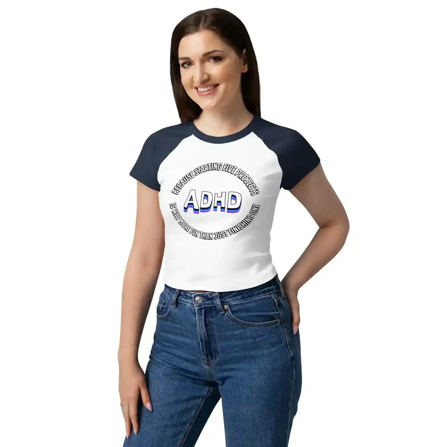 Woman in a Cady Creations graphic baby tee with ADHD text, navy sleeves, and blue jeans