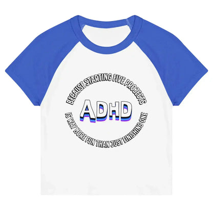 White and royal blue women's graphic baby tee with ADHD text and humorous phrase, Cady Creations